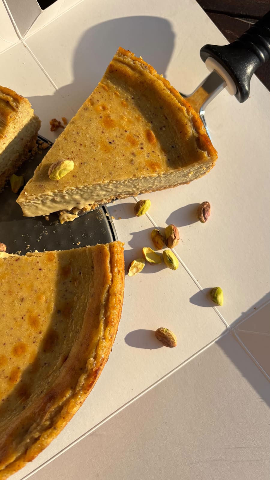 Porcion de tarta vasca Natta de pistacho sobre plato negro