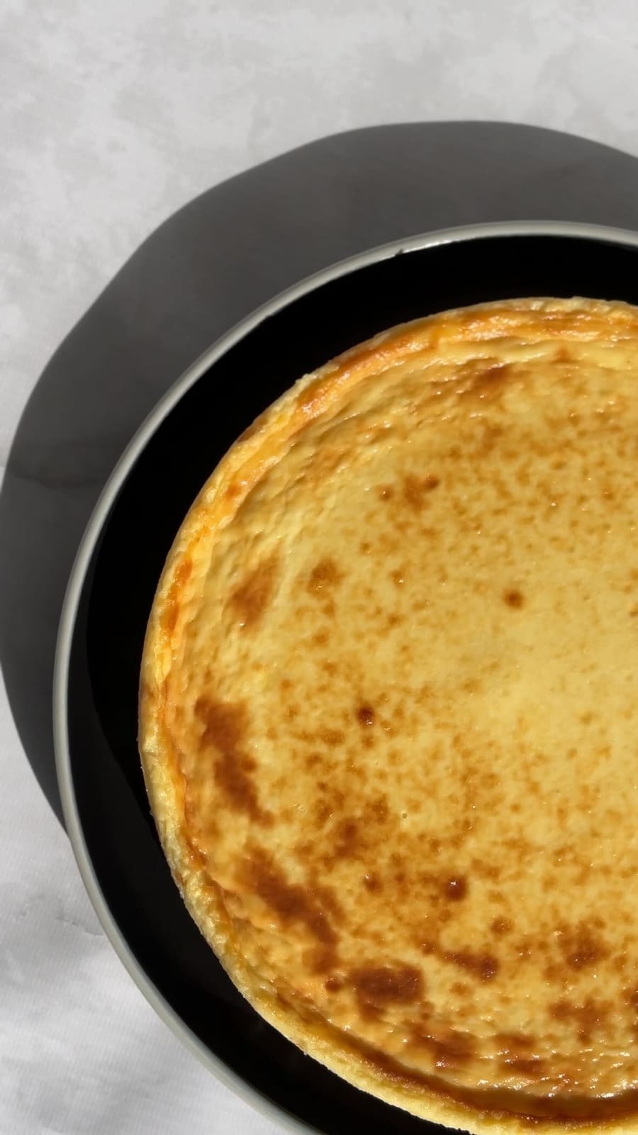 Tarta vasca entera sobre plato negro