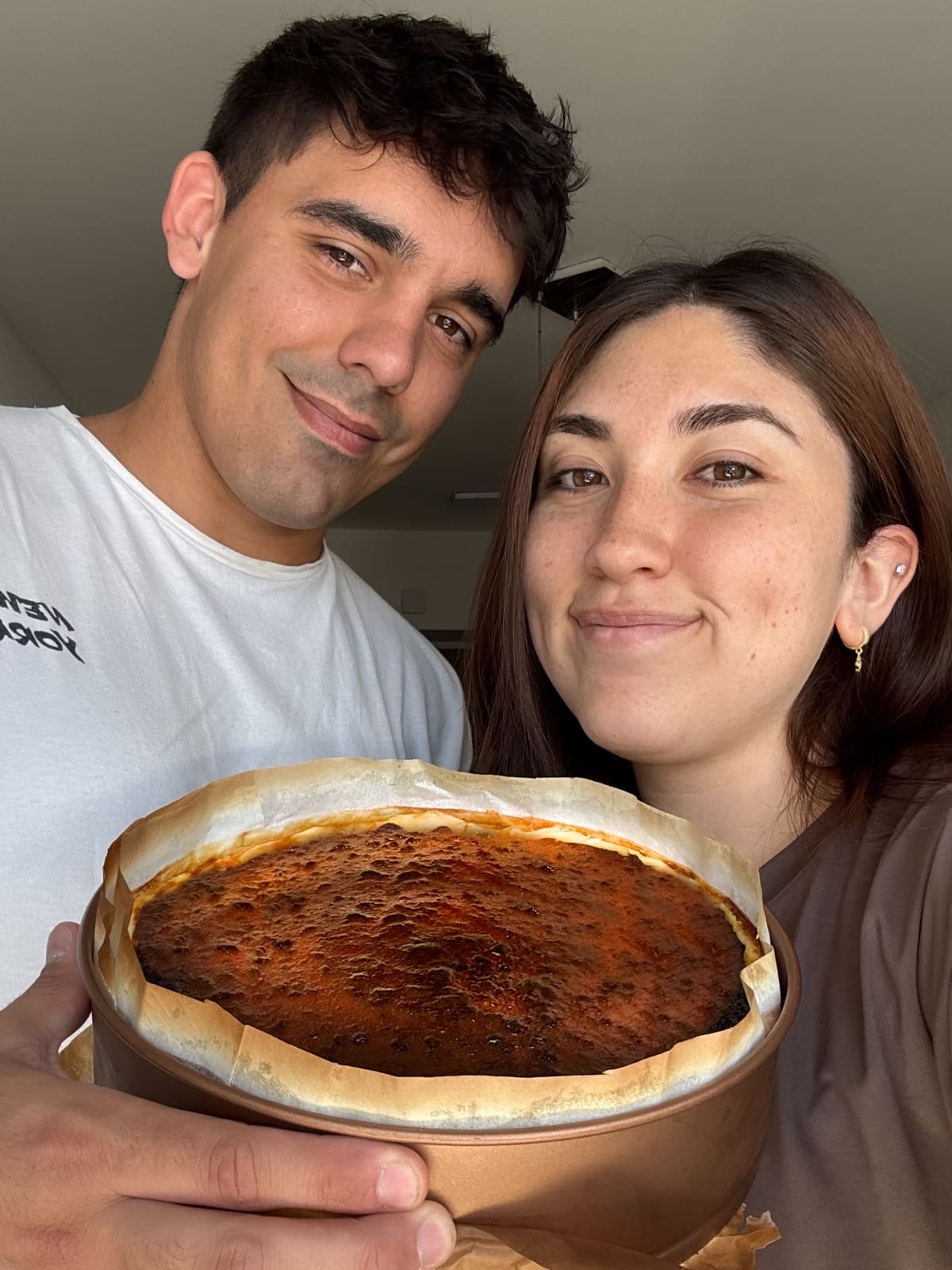 Cami y Martin sosteniendo una tarta vasca Natta